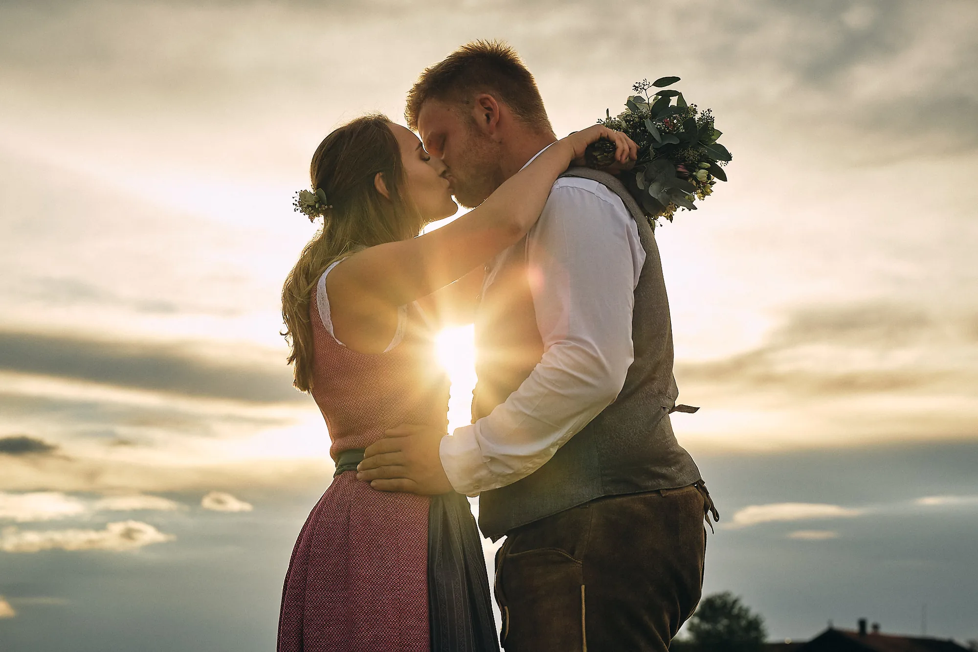 Kuss des Brautpaars im Gegenlicht der Abendsonne – Hochzeitsfotograf aus Niederbayern